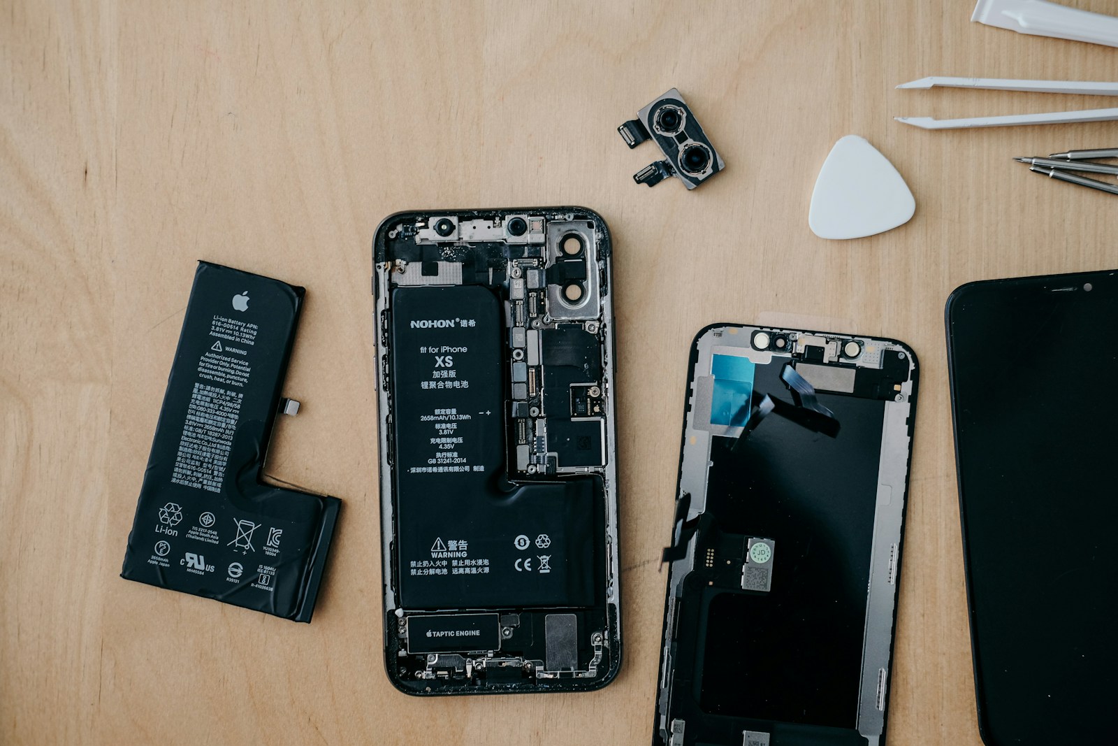 Geöffnetes iPhone mit Ersatzteilen und Reparatur-Werkzeug